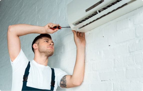 Skilled AC installer testing airflow and electrical connections on newly installed cooling system
