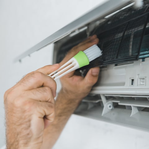 Skilled AC installer testing airflow and thermostat settings on newly installed system